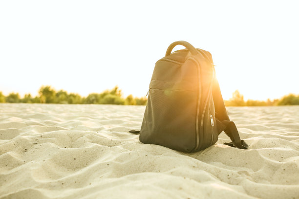 黑人背着背包站在沙滩上。本空间图片下载