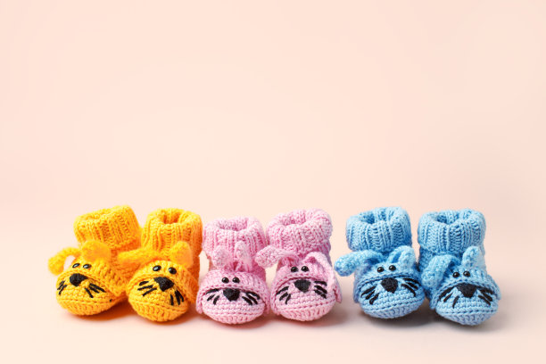 怀孕为人母的概念，三双彩色背景的婴儿靴，婴儿送礼会，一岁生日派对横幅，手工袜子，日托，幼儿园，托儿所，妈妈妈妈图片下载