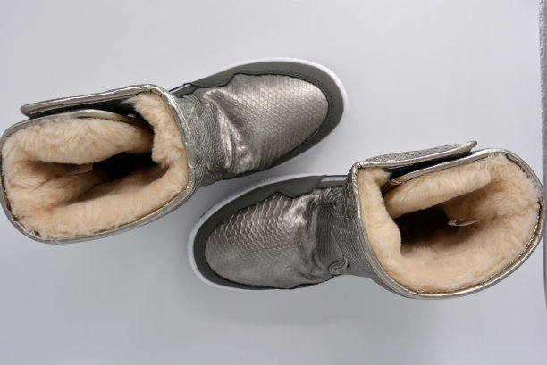 女性冬季防水靴。银色，青铜色的暖靴。运动温暖的鞋在一个非常厚的白色平台。图片下载