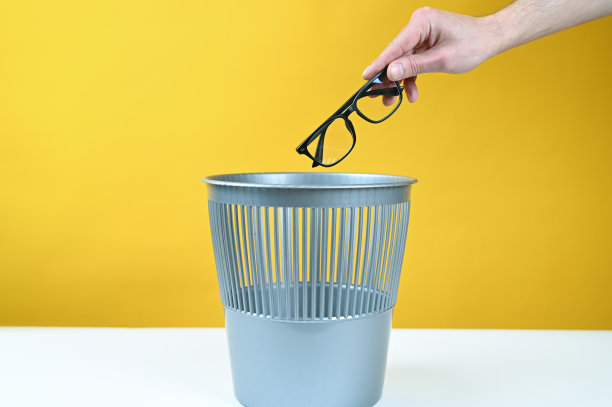 手把玻璃杯扔进垃圾桶图片下载