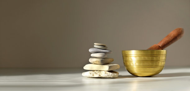 灰色背景的桌子上放着藏歌碗和石金字塔。横幅,复制空间图片下载