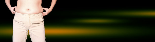 女性腹部肥大，手托腹部脂肪过多，脂肪团。减肥、节食和养成健康的生活方式。图片下载