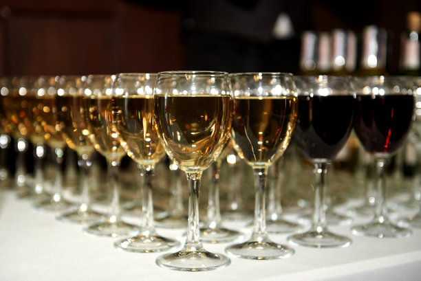 餐厅、复印空间的餐桌上，配有葡萄酒和香槟的闪闪发光的玻璃器皿。准备好庆祝的水晶酒杯。豪华婚宴上的酒杯图片下载