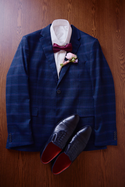 优雅的男蓝色西装与白色衬衫，领结，黑色鞋和钮扣在木背景，复制空间。现代男人配件。婚礼的细节图片下载