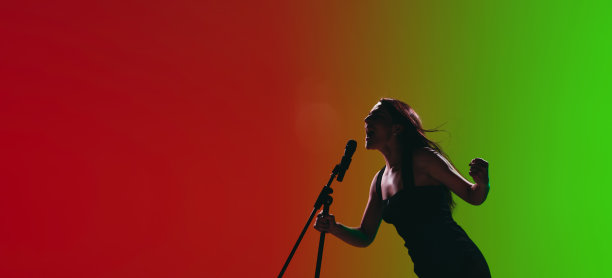 女歌手的肖像孤立在霓虹灯下的红绿背景。图片下载