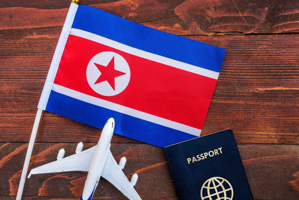 带有护照的朝鲜国旗和木制背景上的玩具飞机图片下载