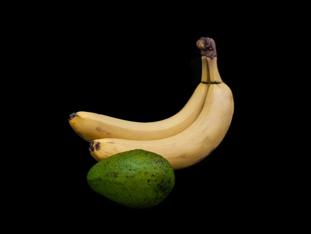 黑色背景上的香蕉和鳄梨图片下载