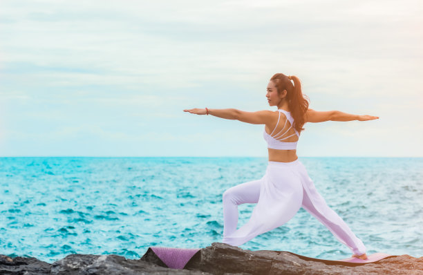 美丽的亚洲女人正在岩石上练习瑜伽图片下载