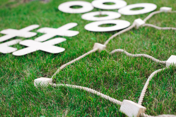 在绿色的草地上玩井字游戏。图片下载