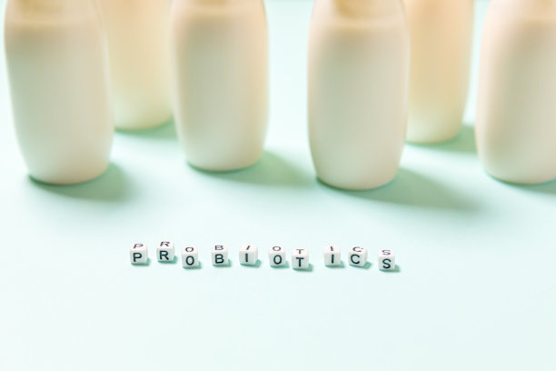 小瓶益生菌和益生元牛奶饮料在蓝色背景。使用生物活性添加剂生产。发酵和饮食健康食品。含有有益微生物的生物酸奶图片下载