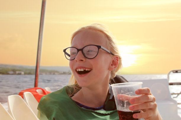 年轻的金发女孩戴眼镜有乐趣发现岛屿夏季沿海巡航。冒险旅行，和孩子们一起乘游艇度假。图片下载