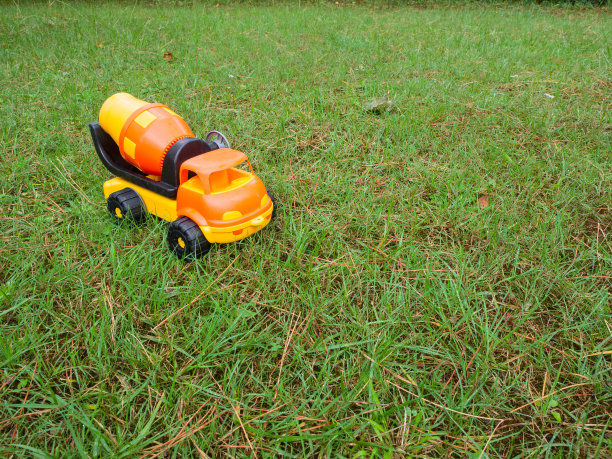 卡车水泥(混凝土)搅拌机塑料玩具在花园里的草地上图片下载