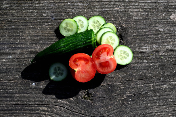 木桌上放着黄瓜、萝卜和西红柿图片下载