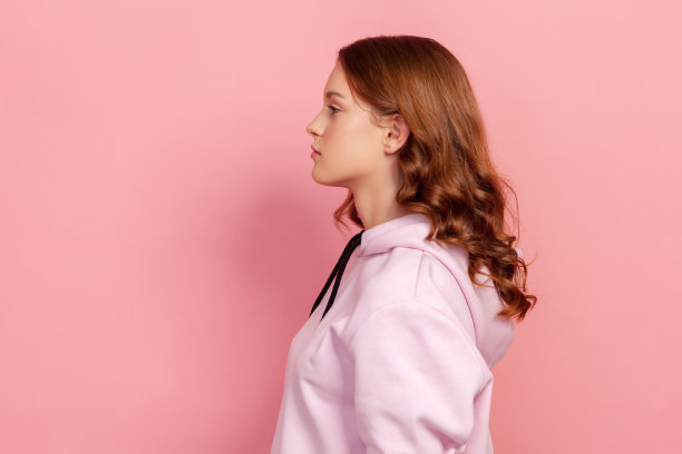 侧影严肃的黑发少女在帽衫关注左图片下载