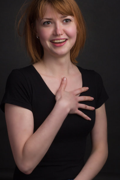 画室里一个棕色头发的年轻女人的肖像，以黑色为背景图片下载