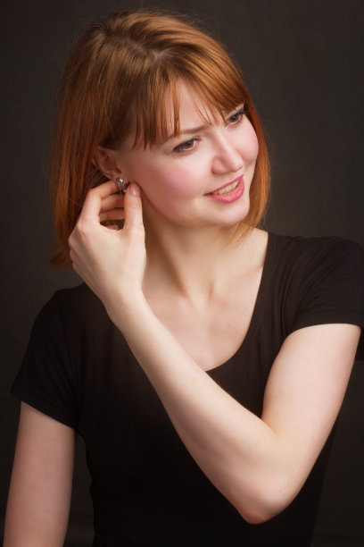 画室里一个棕色头发的年轻女人的肖像，以黑色为背景图片下载