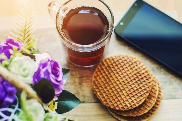 茶点、饼干和一部电话在一张木桌上。图片下载