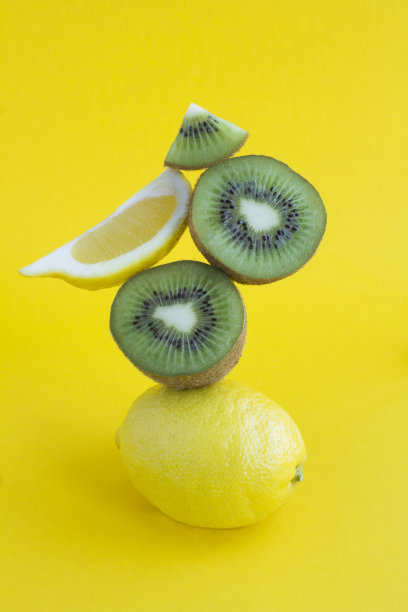 柠檬和猕猴桃堆叠在黄色的背景金字塔图片下载