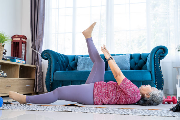 肖像健康的老年妇女运动与躺抬腿图片下载