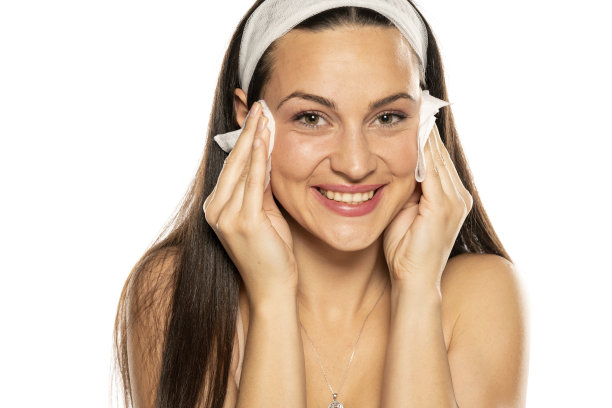 微笑的年轻女子用湿纸巾擦脸图片下载