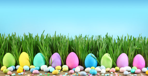 草地上画的复活节彩蛋和五颜六色的复活节糖果。图片下载