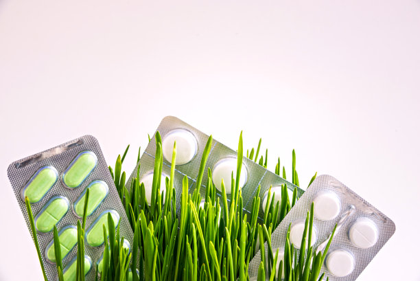 绿色的草和药丸的水泡孤立在白色的背景图片下载