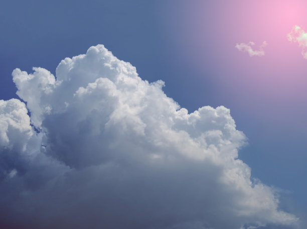 大朵白云映衬着阳光。蓝色的雷暴的背景。图片下载