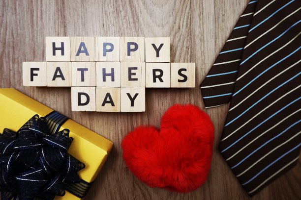 快乐的父亲节字母与领带礼盒和红心绒毛在木制的背景图片下载