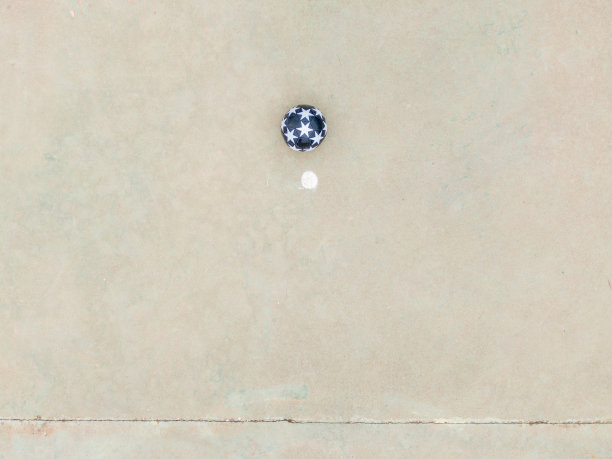 俯视图的一个球在一个白点旁边的体育场地的地板上图片下载