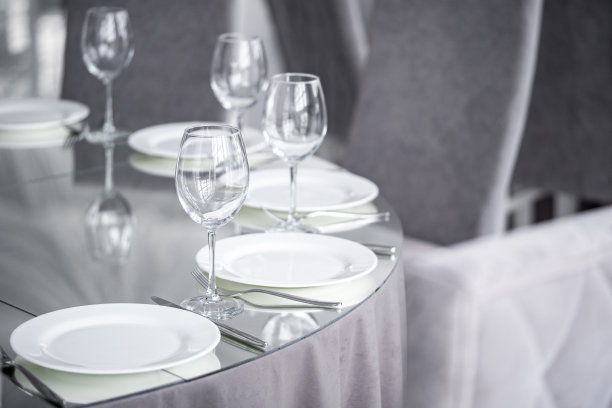 干净透明的酒杯放在镜面的桌面上。服务和时尚简约的晚餐装饰。图片下载