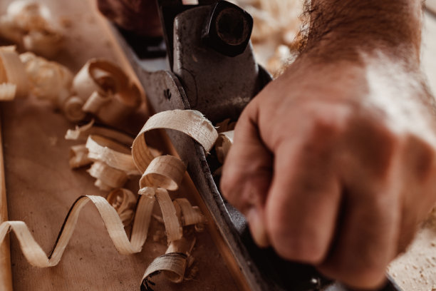 木匠的手用手刨刨一块木板图片下载