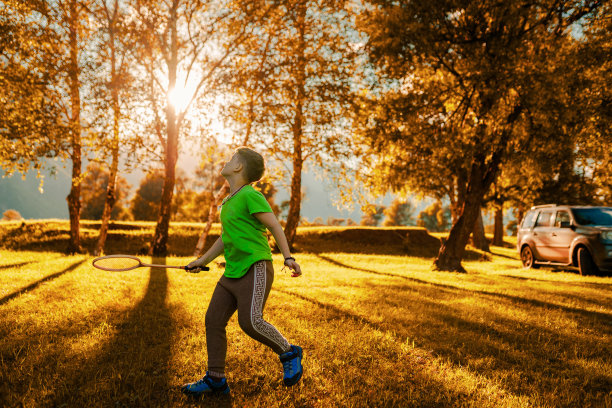 一个小男孩在户外打羽毛球图片下载