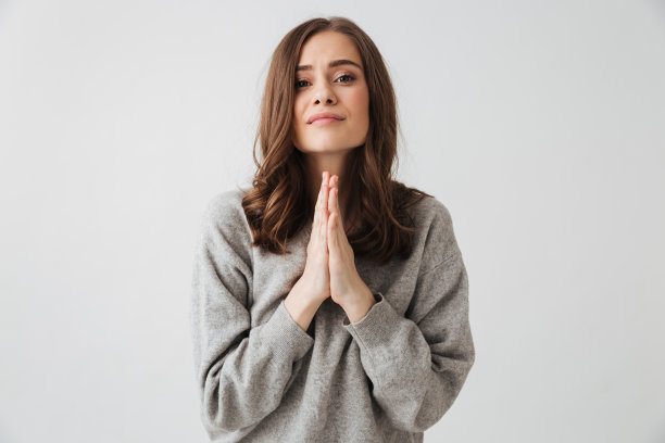 专注的深褐色的女人在毛衣祈祷祈祷手势图片下载