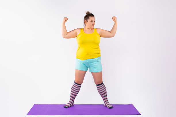 高加索曲线妇女在明亮的衣服孤立在工作室背景。年轻人和肥胖的概念。图片下载