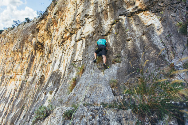攀登者爬在岩壁上。登山装备。登山设备。图片下载