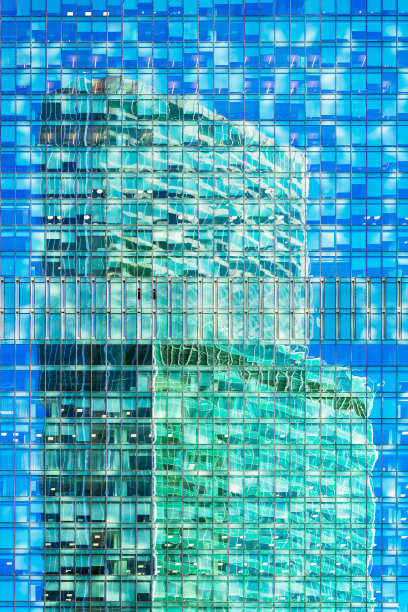 几何抽象的背景玻璃和混凝土建筑，一个摩天大楼的明亮反射在另一个的墙壁图片下载