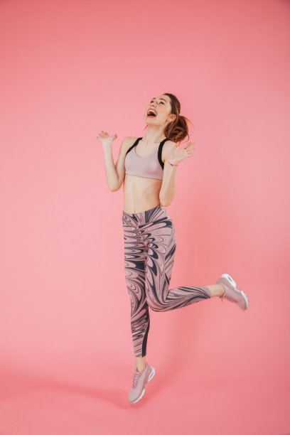 尖叫的女运动员跳跃和欣喜的全长图像图片下载