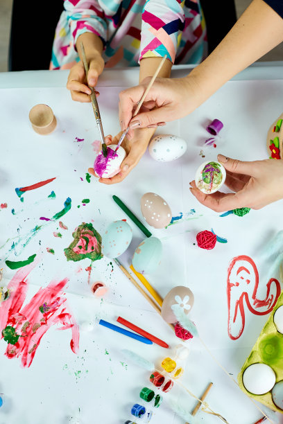 俯视图不认识的母亲和她的女儿在复活节假期着色复活节蛋图片下载