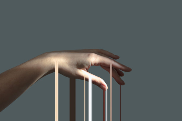 在灰色的背景上，柔软的女性手的光条纹缓缓流下。图片下载