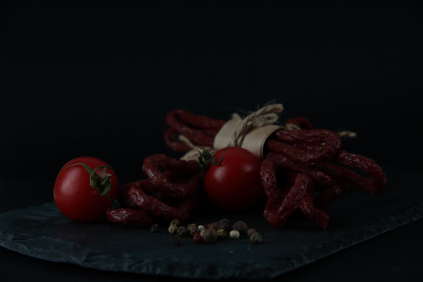 卡巴诺斯或卡巴诺斯-传统的波兰薄干烟熏香肠，由牛肉和香草在黑色背景图片下载