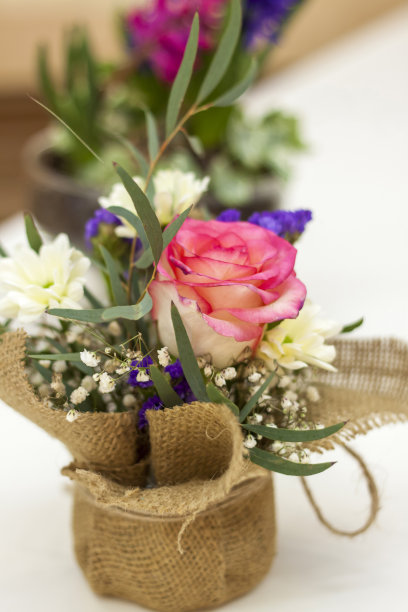 漂亮的插花在一个用粗麻布包裹的罐子里。图片下载