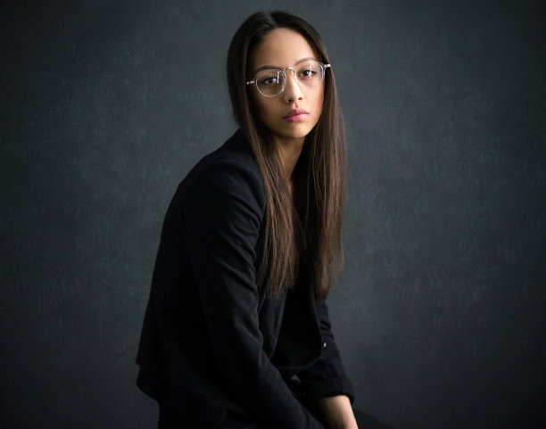 一个戴眼镜穿黑夹克的孤独女人。有一头直发的迷人模特的肖像图片下载