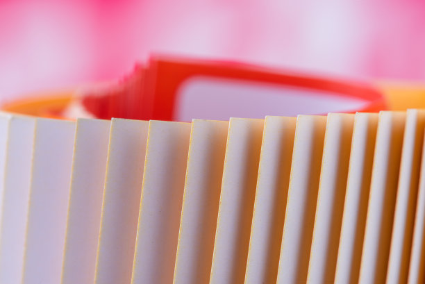 边缘彩色卷起的杂志纸与模糊的背景图片下载