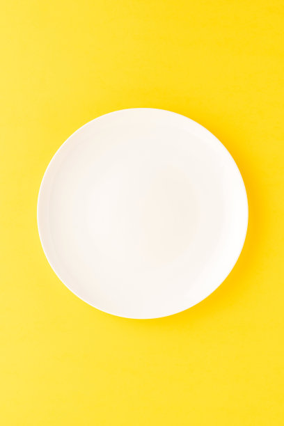 黄色的桌子上空着白色的盘子。俯视图图片下载