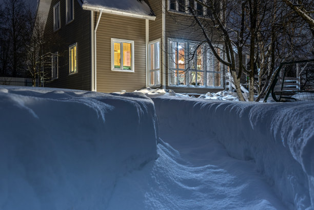 一所乡村房屋的院子里，积雪覆盖着一条小径。晚上农村草图。图片下载