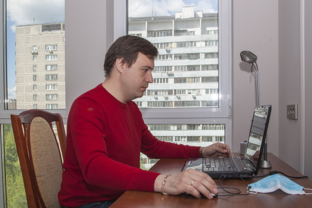 家庭办公室概念，男人企业家坐在家里的桌子上用笔记本电脑工作，学生或自由职业者。图片下载