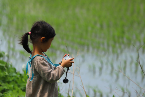 一个女孩在农场里用数码相机拍照图片下载