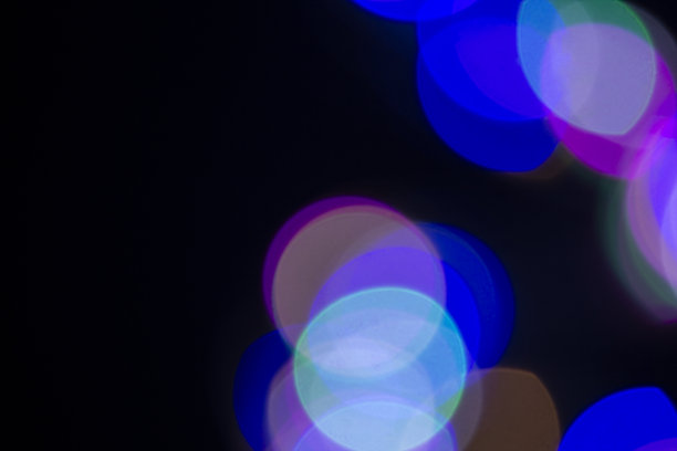 在抽象背景上的彩色圆的散焦图像。黑暗的背景，模糊的散景。图片下载