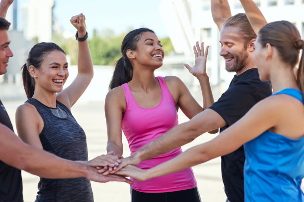 快乐的年轻多种族运动员手牵手堆叠图片下载