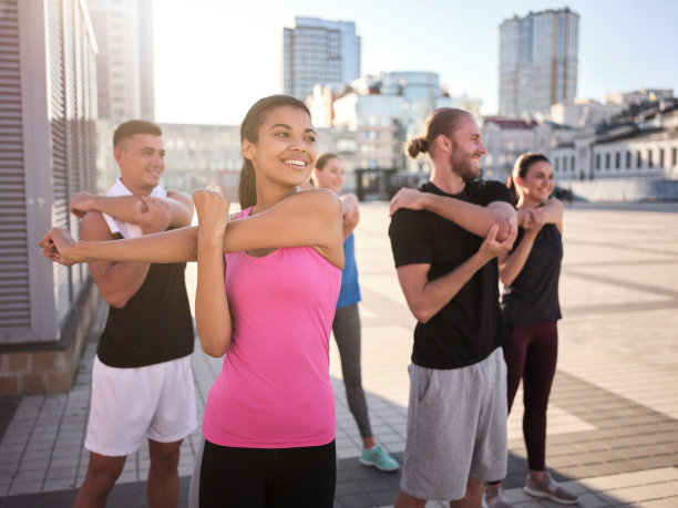 一队快乐的年轻运动员在做手部伸展运动图片下载